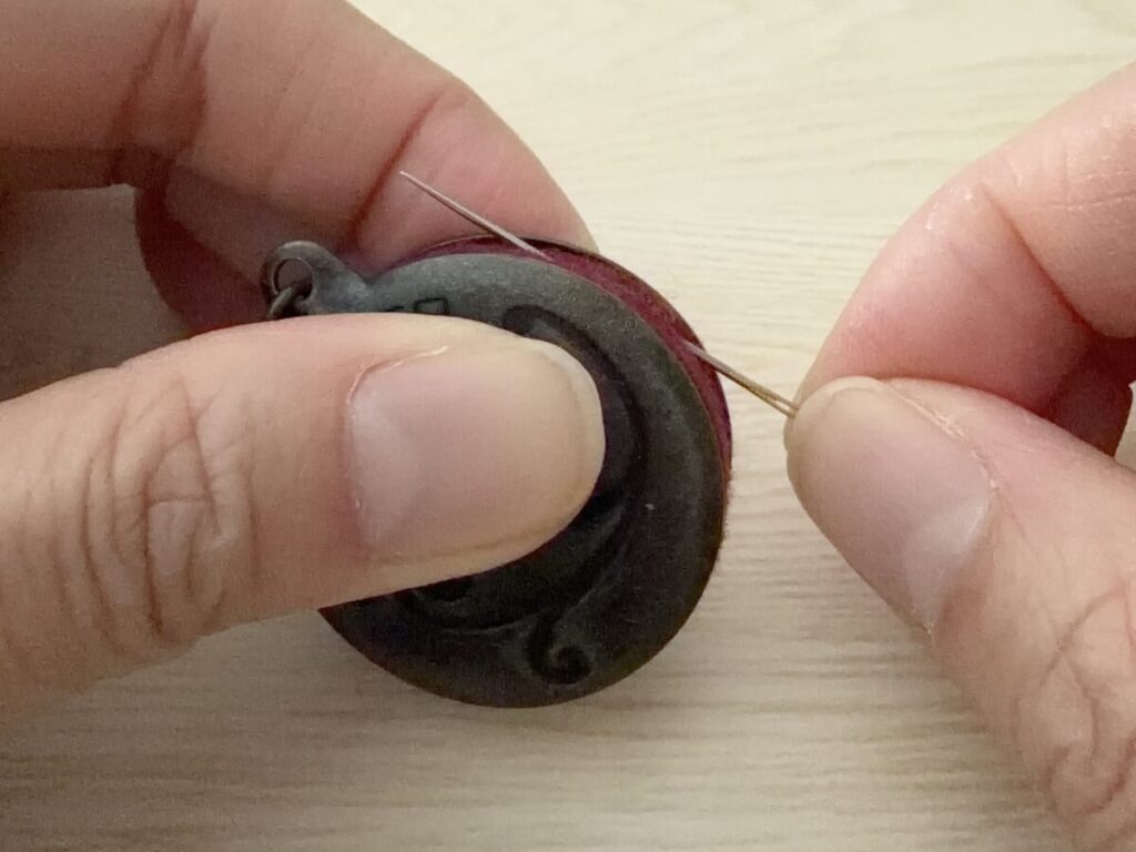 錆びた刺繍針を針磨きで磨いているところ